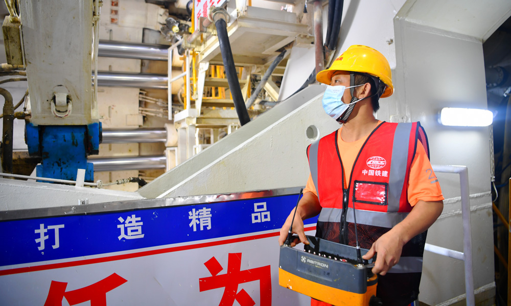 全长9640米的湛江湾海底隧道设计为单洞双线，是全线唯一采用盾构施工法的隧道，其中7551米盾构区间由一台开挖直径14.33米的盾构机完成施工，是我国目前独头掘进距离最长的大直径穿海高铁盾构隧道。图为盾构建设者正在拼装管片。