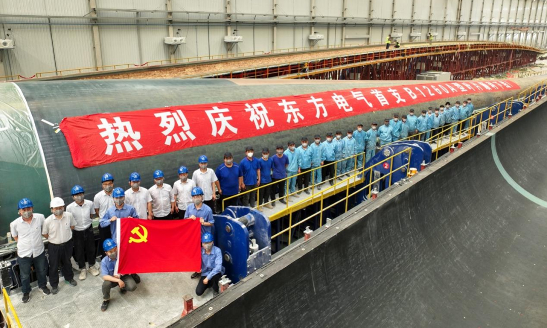 5月28日，东方电气风电股份有限公司自主研制、拥有完全自主知识产权的B1260A型叶片，在江苏叶片制造基地顺利下线，该叶片长126米，是目前全球已下线的最长风电叶片。同日，东方风电自主研制的B1200A型叶片一次性顺利通过静力试验，各项测试指标与设计值良好吻合，120米级叶片的材料、结构、工艺及质量控制得到了充分有效验证。图为东方电气B1260A型叶片下线现场。